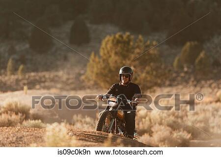 Motorbiker riding through landscape of Kennedy Meadows, California, US View Large Photo Image Picture - Motorbiker riding through landscape of Kennedy Meadows, California, US. Fotosearch
