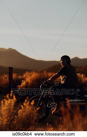 Motorbiker riding through landscape of Kennedy Meadows, California, US View Large Photo Image Picture - Motorbiker riding through landscape of Kennedy Meadows, California, US. Fotosearch