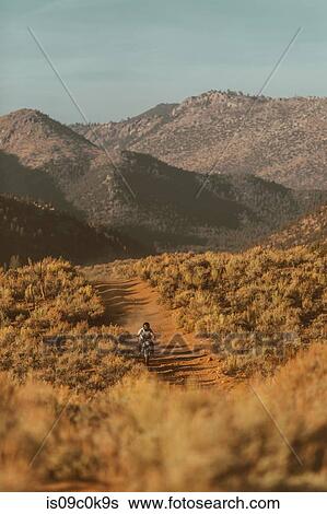 Motorbiker riding through landscape of Kennedy Meadows, California, US View Large Photo Image Stock Photograph - Motorbiker riding through landscape of Kennedy Meadows, California, US. Fotosearch