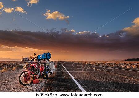 Stock Photography - Motorcycle on roadside, getting away from a huge windstorm between Nevada and California, Bishop, California, United States. Fotosearch