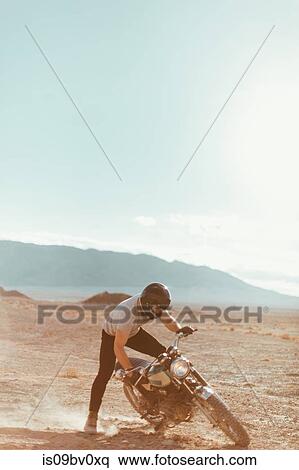 Stock Photography - Motorcyclist enjoying stunts, Trona Pinnacles, California, US. Fotosearch