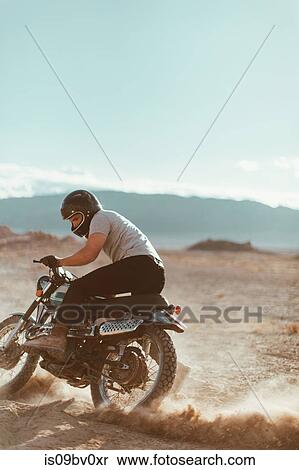 Stock Photography - Motorcyclist enjoying stunts, Trona Pinnacles, California, US. Fotosearch
