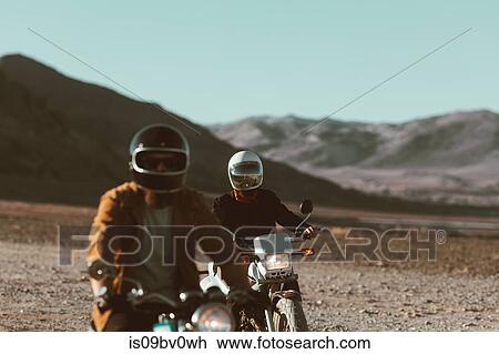 Stock Image - Motorcyclist friends riding in desert, Trona Pinnacles, California, US. Fotosearch
