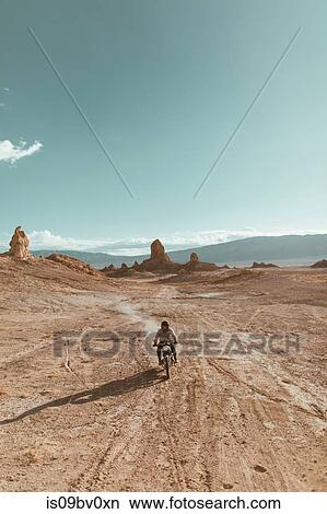 Motorcyclist riding in desert, Trona Pinnacles, California, US View Large Photo Image Picture - Motorcyclist riding in desert, Trona Pinnacles, California, US. Fotosearch