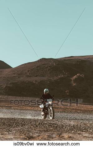 Stock Image - Motorcyclist riding in desert, Trona Pinnacles, California, US. Fotosearch