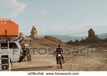 Stock Image - Motorcyclist riding in desert, Trona Pinnacles, California, US. Fotosearch