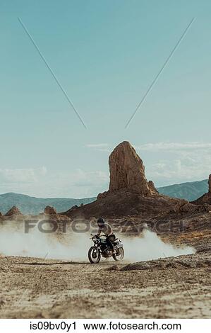 Stock Image - Motorcyclist riding in desert, Trona Pinnacles, California, US. Fotosearch