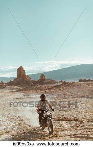 Stock Photograph - Motorcyclist riding in desert, Trona Pinnacles, California, US. Fotosearch