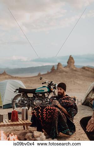 Picture - Motorcyclist road trippers around camp fire, Trona Pinnacles, California, US. Fotosearch