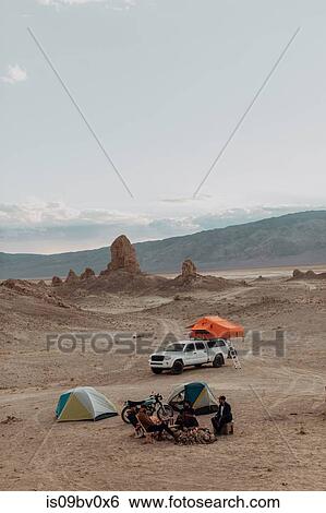 Stock Photograph - Motorcyclist road trippers around camp fire, Trona Pinnacles, California, US. Fotosearch