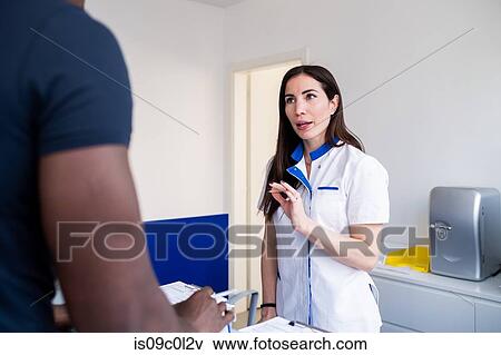Nurse speaking with patient at hospital reception View Large Photo Image Stock Photo - Nurse speaking with patient at hospital reception. Fotosearch