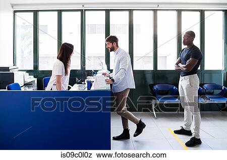 Nurse speaking with patients at hospital reception View Large Photo Image Stock Photo - Nurse speaking with patients at hospital reception. Fotosearch