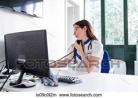 Nurse talking on telephone in hospital View Large Photo Image Picture - Nurse talking on telephone in hospital. Fotosearch