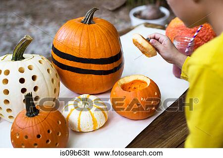 Over shoulder view of boy lifting pumpkin lid on garden table View Large Photo Image Stock Photograph - Over shoulder view of boy lifting pumpkin lid on garden table. Fotosearch