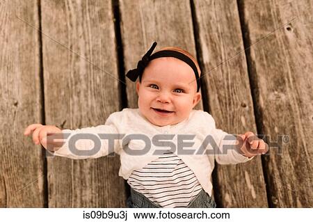 Overhead portrait of baby girl lying on wooden planks View Large Photo Image Stock Image - Overhead portrait of baby girl lying on wooden planks. Fotosearch