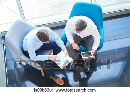 Overhead view of business men with digital tablet in meeting View Large Photo Image Stock Photography - Overhead view of business men with digital tablet in meeting. Fotosearch