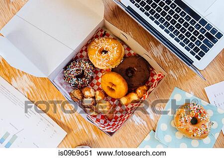 Overhead view of doughnuts in cake box on desk View Large Photo Image Stock Image - Overhead view of doughnuts in cake box on desk. Fotosearch