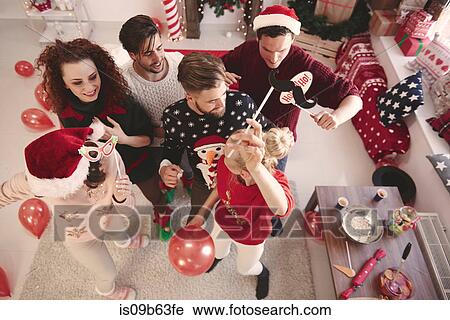Stock Image - Overhead view of young adult friends dancing at christmas party. Fotosearch