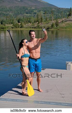 Paddleboarding couple taking selfie on lake pier, Frisco, Colorado, USA View Large Photo Image Stock Photography - Paddleboarding couple taking selfie on lake pier, Frisco, Colorado, USA. Fotosearch