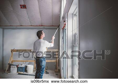 Painter decorator working inside building View Large Photo Image Stock Photo - Painter decorator working inside building. Fotosearch