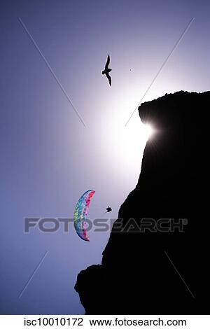 Paraglider gliding mid air near cliff against blue sky, Vik, Iceland View Large Photo Image Stock Image - Paraglider gliding mid air near cliff against blue sky, Vik, Iceland. Fotosearch