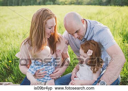 Stock Photography - Parents and children relaxing in park. Fotosearch