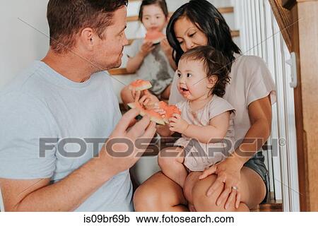 Parents enjoying watermelon with daughters on stairs View Large Photo Image Stock Image - Parents enjoying watermelon with daughters on stairs. Fotosearch
