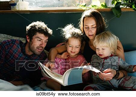 Parents reading to children in bed View Large Photo Image Stock Photo - Parents reading to children in bed. Fotosearch