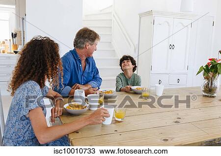 Parents watching son smile at breakfast at home View Large Photo Image Stock Image - Parents watching son smile at breakfast at home. Fotosearch