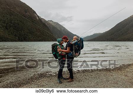 Stock Photograph - Parents with baby kissing on beach, Queenstown, Canterbury, New Zealand. Fotosearch