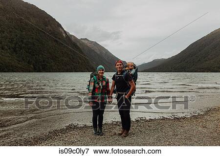 Stock Photo - Parents with baby on beach, Queenstown, Canterbury, New Zealand. Fotosearch