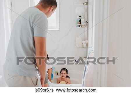Parents with crying daughter at bath time View Large Photo Image Stock Photograph - Parents with crying daughter at bath time. Fotosearch