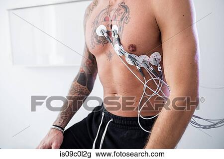 Stock Image - Patient undergoing ECG test in consultation room. Fotosearch