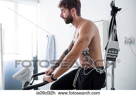 Stock Image - Patient undergoing ECG test in consultation room. Fotosearch