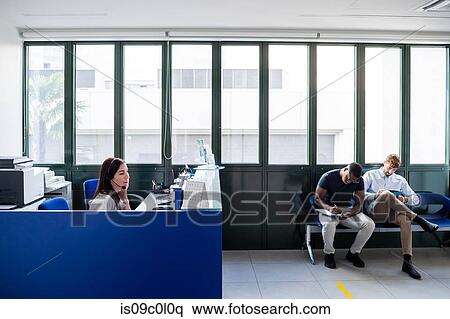 Patients completing forms at hospital reception View Large Photo Image Stock Photography - Patients completing forms at hospital reception. Fotosearch