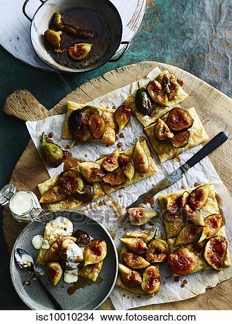 Pieces of figs on crackers served on cutting board View Large Photo Image Picture - Pieces of figs on crackers served on cutting board. Fotosearch