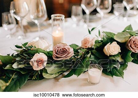 Place setting at wedding reception table with rose garland decoration, candles and drinking glasses View Large Photo Image Stock Photo - Place setting at wedding reception table with rose garland decoration, candles and drinking glasses. Fotosearch