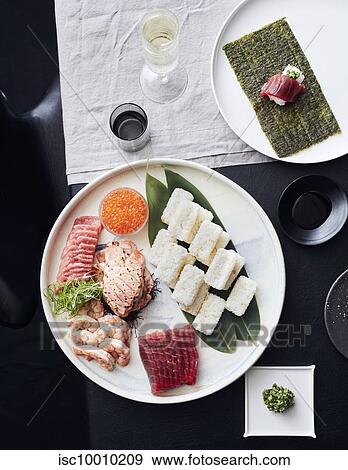 Plate of sashimi and sushi served with white wine View Large Photo Image Stock Photo - Plate of sashimi and sushi served with white wine. Fotosearch