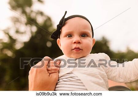 Stock Image - Portrait of baby girl holding mothers hand, close up. Fotosearch
