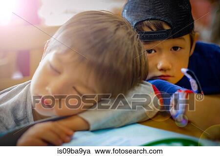 Stock Image - Portrait of boy and sleeping brother. Fotosearch