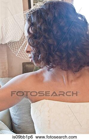 Stock Photograph - Portrait of bride wearing wedding dress and veil, looking away, close-up. Fotosearch