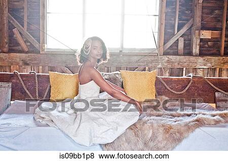Portrait of bride wearing wedding dress, sitting in barn View Large Photo Image Stock Photo - Portrait of bride wearing wedding dress, sitting in barn. Fotosearch