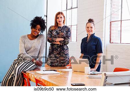Portrait of colleagues in office looking at camera smiling View Large Photo Image Stock Image - Portrait of colleagues in office looking at camera smiling. Fotosearch