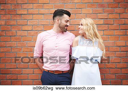 Portrait of couple in front of brick wall face to face smiling View Large Photo Image Stock Image - Portrait of couple in front of brick wall face to face smiling. Fotosearch