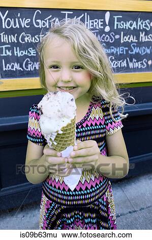 Portrait of cute blond haired girl holding large ice cream cone View Large Photo Image Stock Photograph - Portrait of cute blond haired girl holding large ice cream cone. Fotosearch