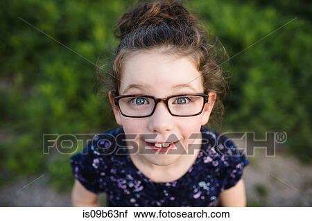 Portrait of cute girl wearing eye glasses looking up at camera View Large Photo Image Stock Image - Portrait of cute girl wearing eye glasses looking up at camera. Fotosearch