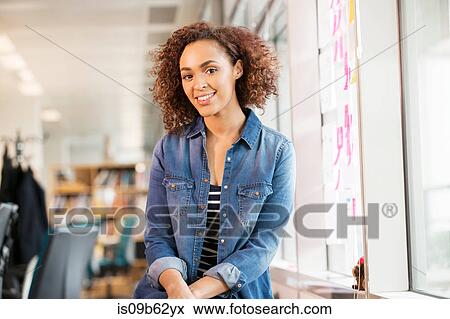 Stock Photo - Portrait of female digital designer on office desk. Fotosearch
