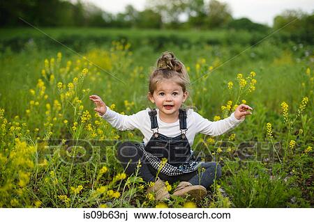 Portrait of girl cross legged in wildflower meadow View Large Photo Image Stock Image - Portrait of girl cross legged in wildflower meadow. Fotosearch