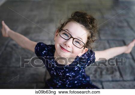 Portrait of girl wearing eye glasses looking up at camera View Large Photo Image Stock Image - Portrait of girl wearing eye glasses looking up at camera. Fotosearch