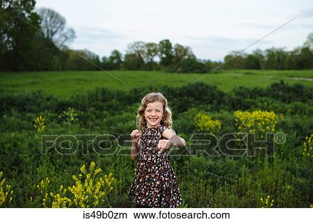 Portrait of girl with wavy blond hair punching in field View Large Photo Image Picture - Portrait of girl with wavy blond hair punching in field. Fotosearch